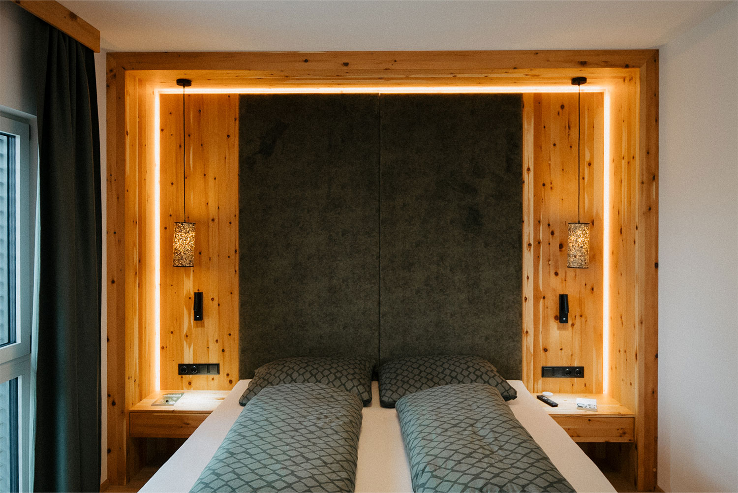 Schlafzimmer mit beleuchteter Altholz-Rückwand